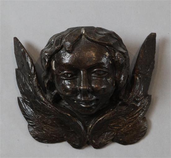 An early 16th century carved wood and painted gesso model of winged amorini bust, 5 x 6.25in.